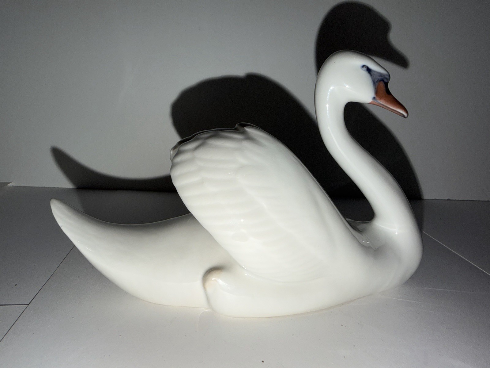 A Royal Copenhagen porcelain figurine of a white swan with painted beak details.