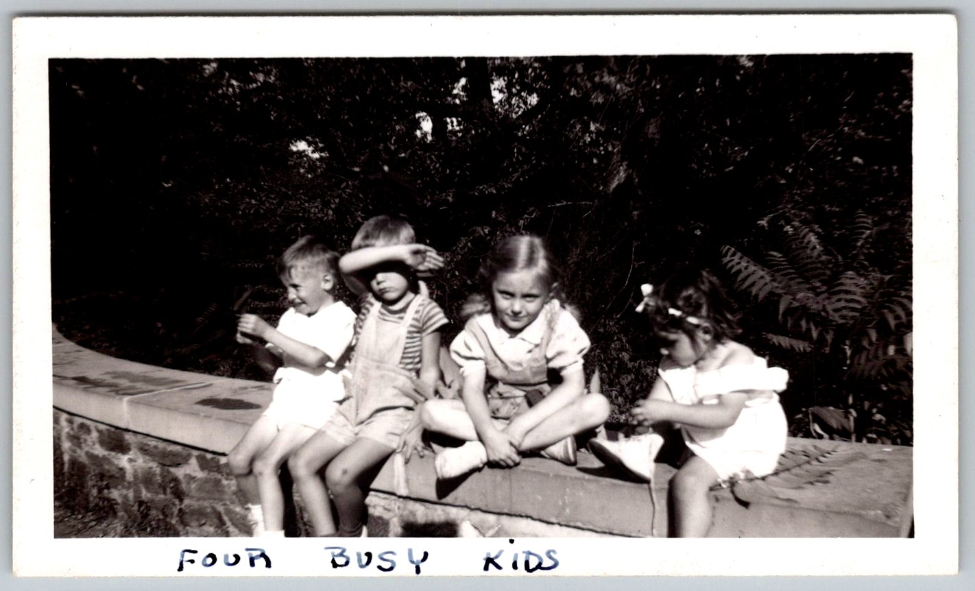 Vtg B&W Snapshot Four Busy Kids Sitting Stone Ledge Wall Outside Black White