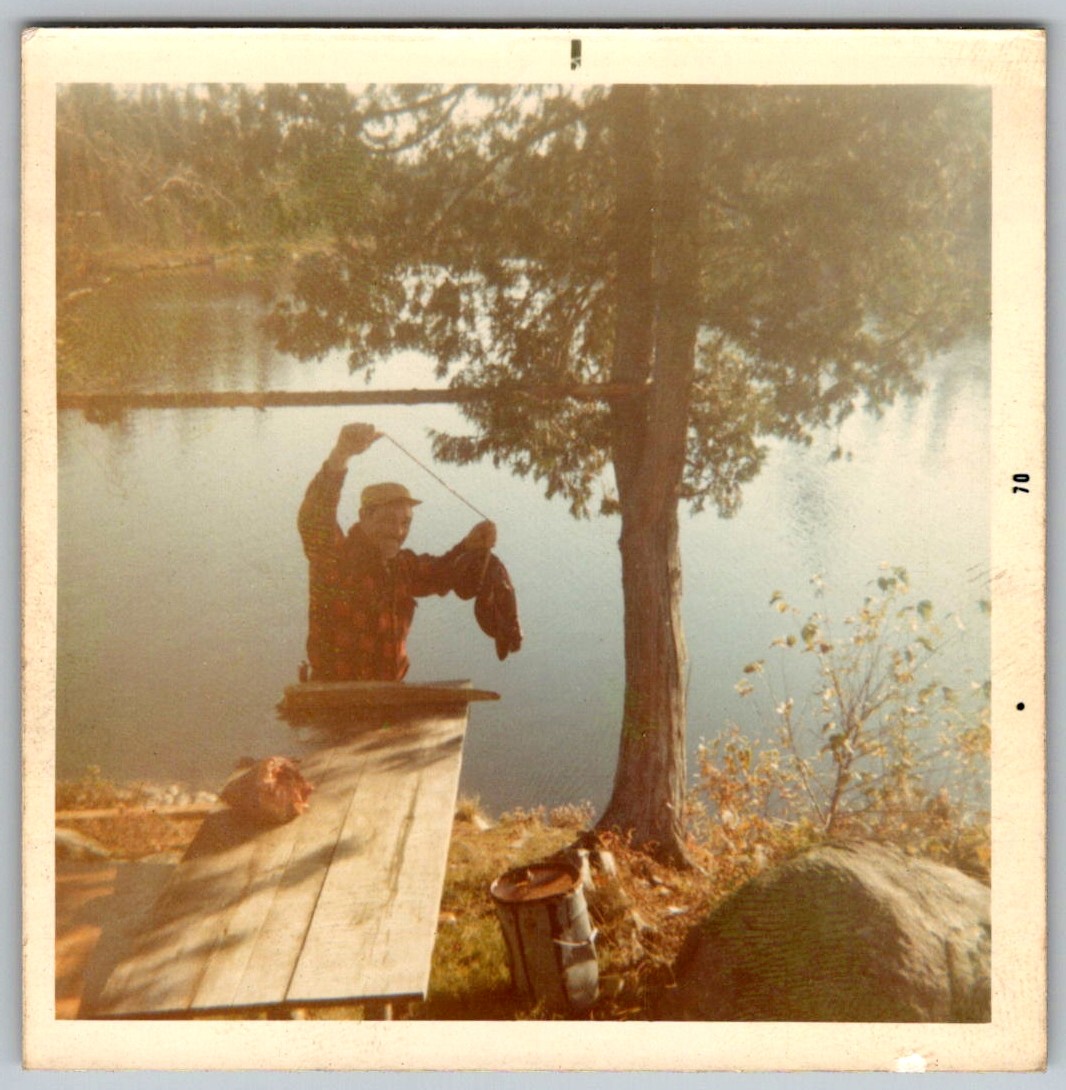 Vtg Color Snapshot Man In Red Plaid Shirt Holding Fish By Lake Fishing 1970